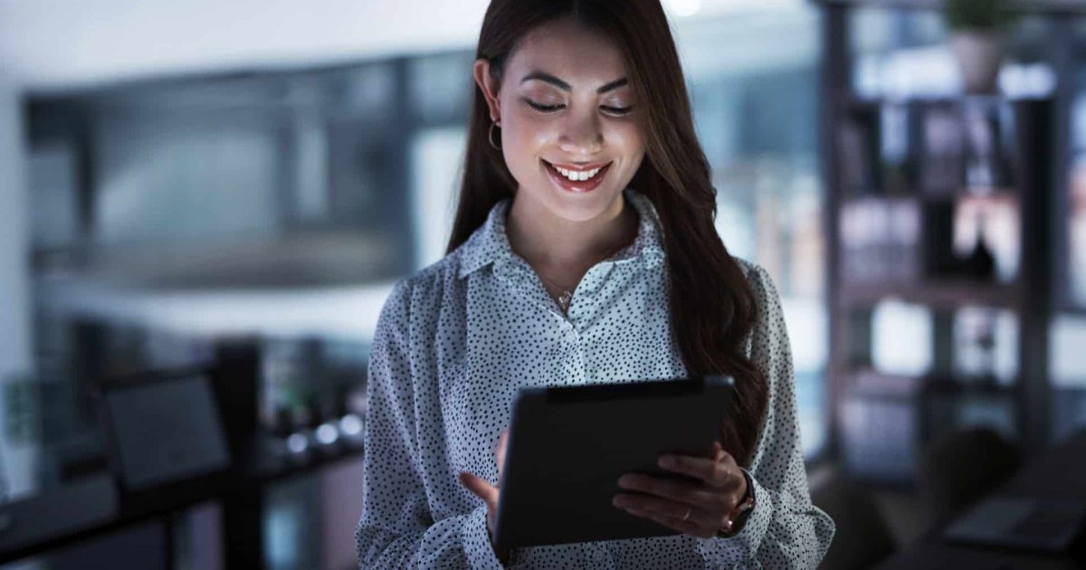 Shot of a young businesswoman using a digital tablet in an office at night.